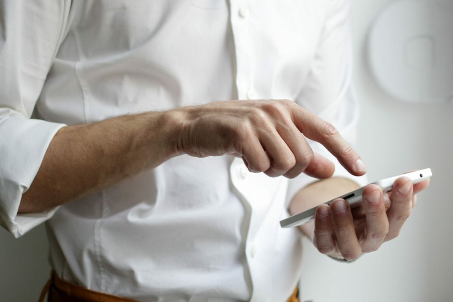 Hand tippt af Handy. Marketing und Projekt Management, Alexander Herweg
